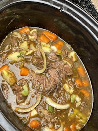 a crock pot full of beef and vegetables