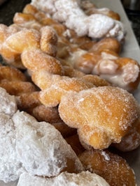 a box of donuts with powdered sugar on top