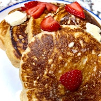 pancakes with butter and strawberries on a plate